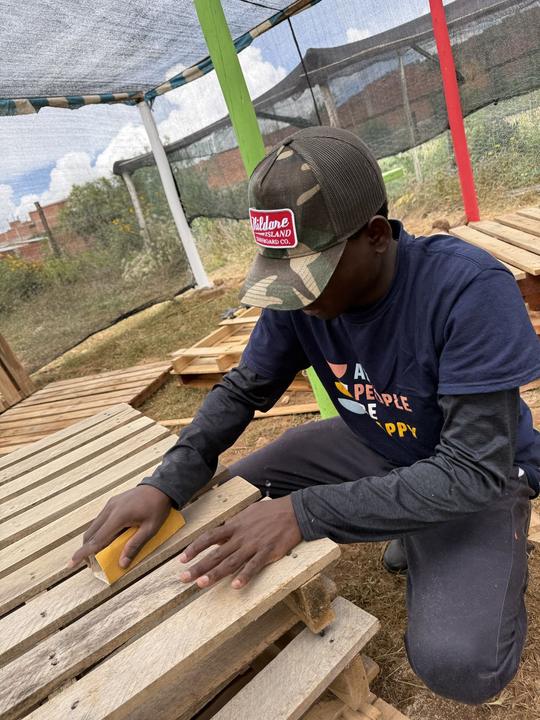 Sanding pallet wood for the benches.